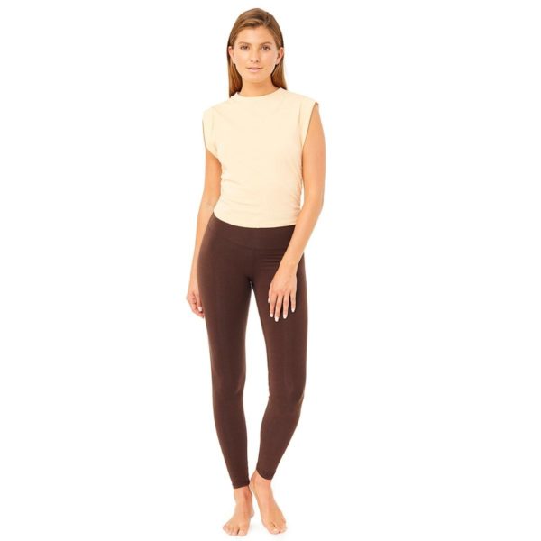 Frau trägt Yoga-Top in Mandarin und braune Yoga-Hose