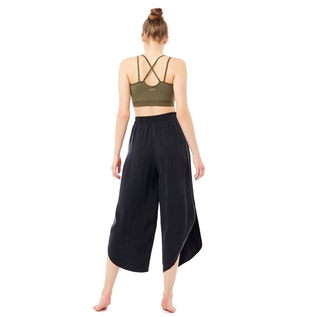 Frau trägt eine schwarze Yogahose und ein grünes Top