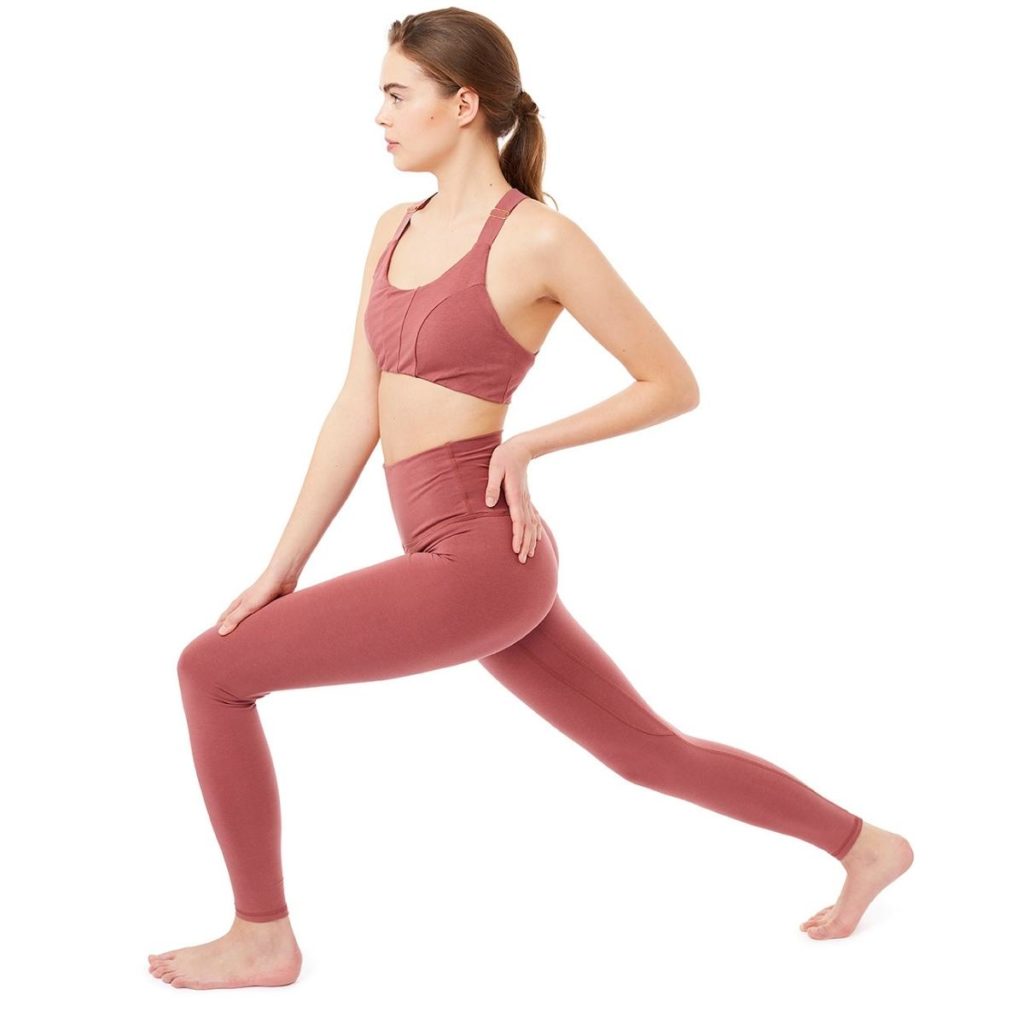 Frau in Yoga Pose in einem roten Yoga Outfit von Mandala