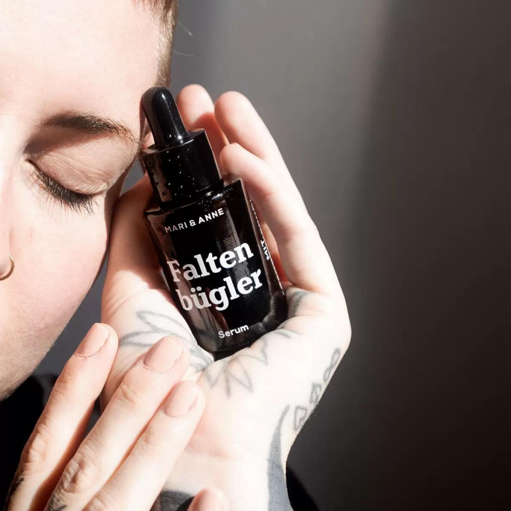 Frau mit geschlossenen Augen hält das Faltenbügler Serum in ihrer Hand