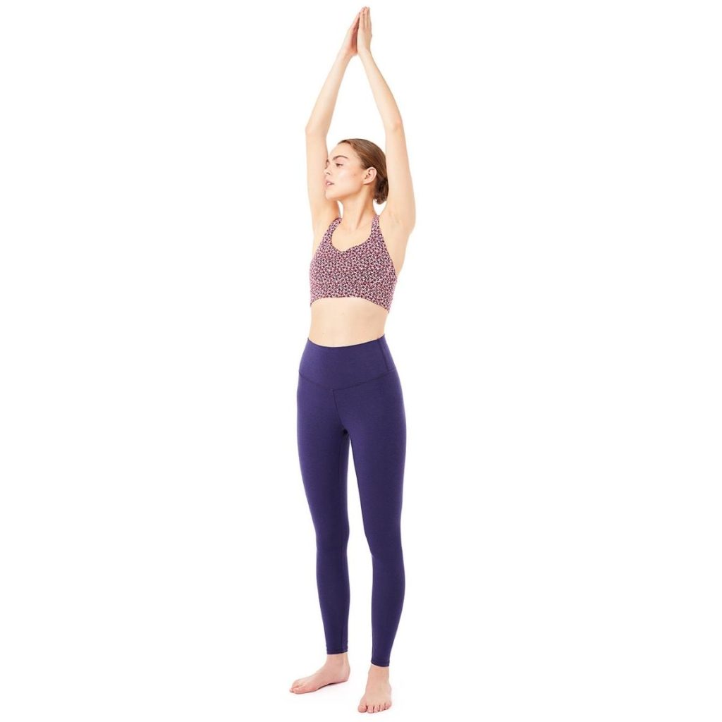 Frau macht Yoga Pose und trägt blaue Yoga Legging und Yoga Top
