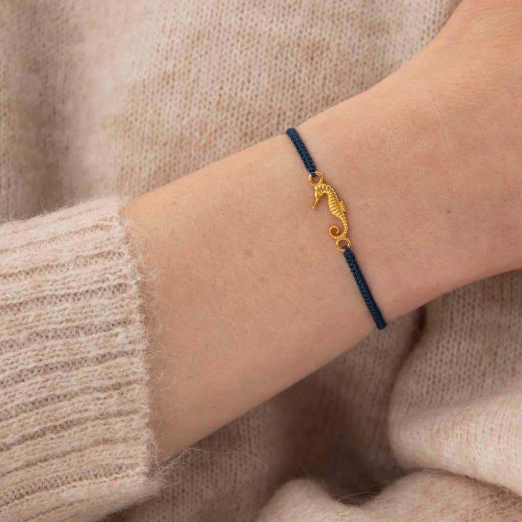 Frau trägt Symbol Seepferdchen Gold Armband