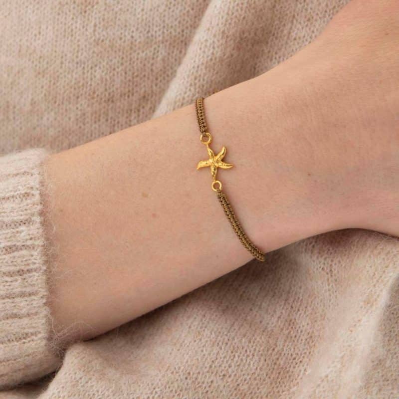 Frau trägt Symbol Seestern Gold Armband